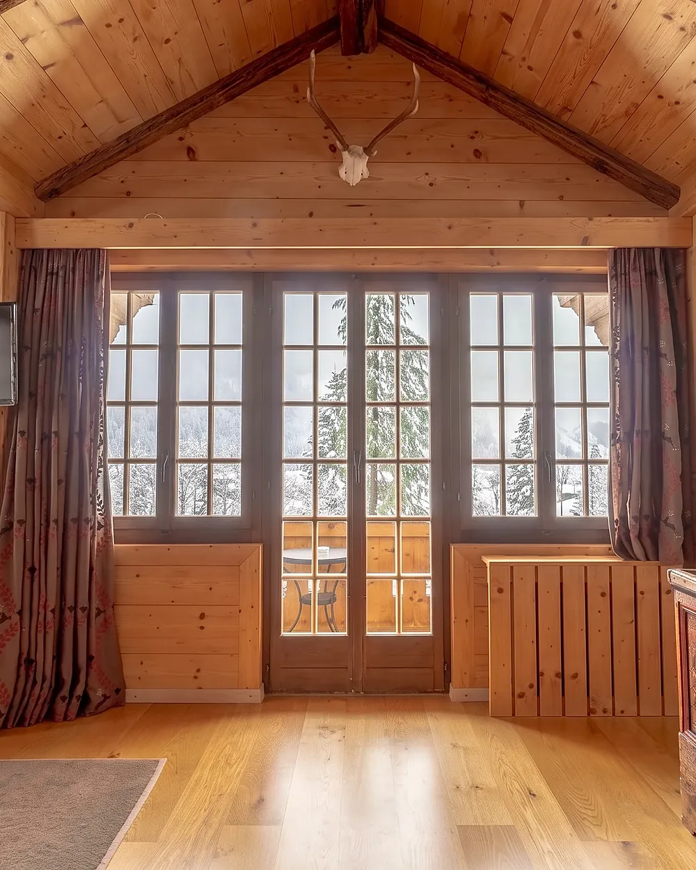 Suite in hellem Holz mit Fenstertüren zum Balkon
