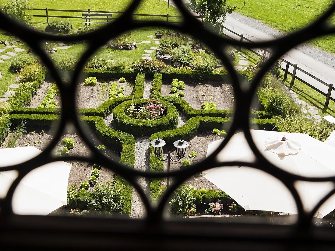 Der Barockgarten, durch ein Fenstergitter gesehen