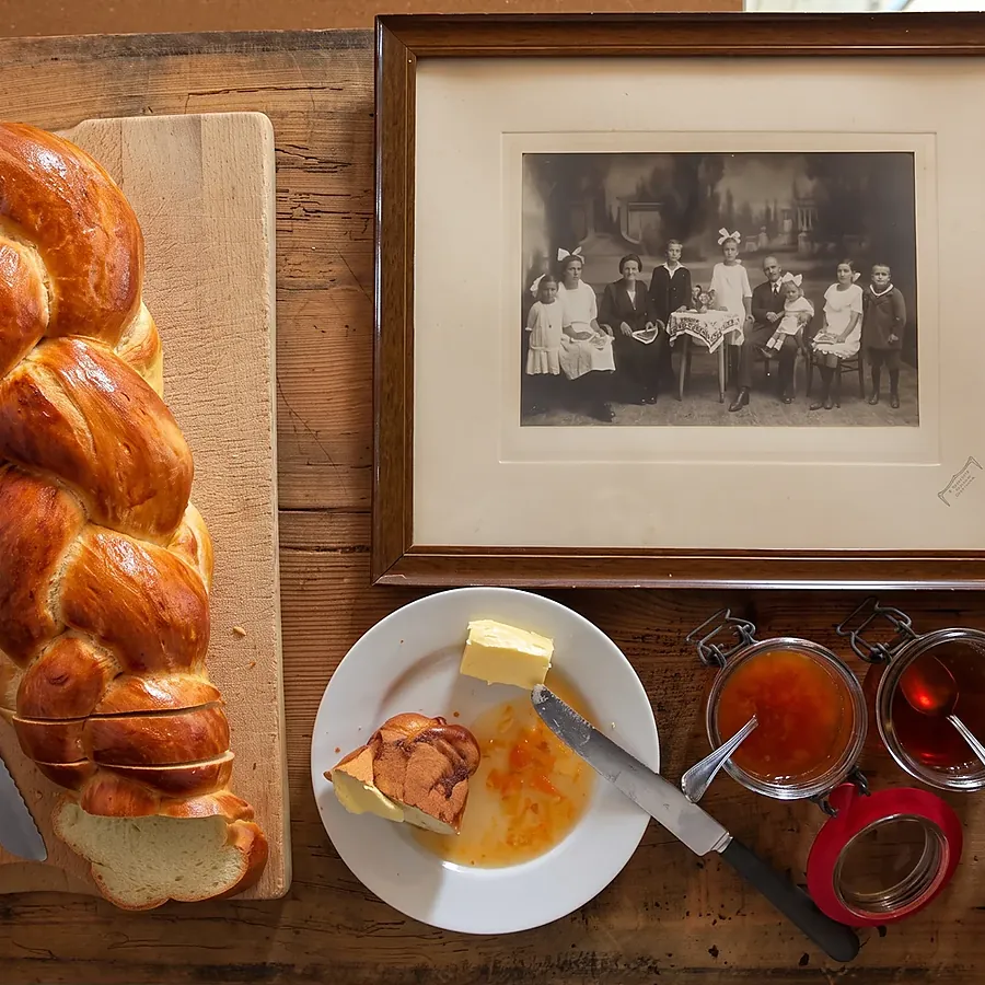 Zopf, Butter und Konfitüre, dahinter ein altes Familienfoto